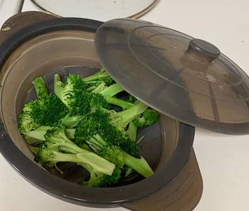 a reviewer photo of the steamer bow with the lid off and filled with steamed broccoli 