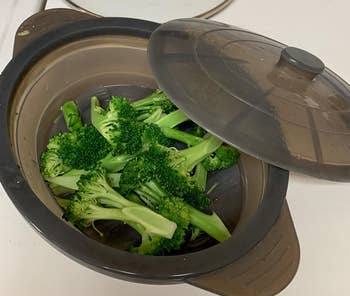 a reviewer's steamer bow with the lid off and filled with steamed broccoli 