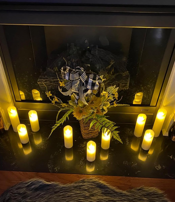 the candles on the ground next to a fireplace