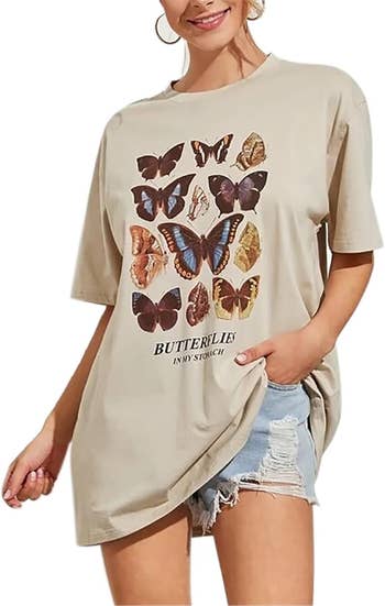 model in a casual butterfly print t-shirt and denim shorts standing with a hand on her hip