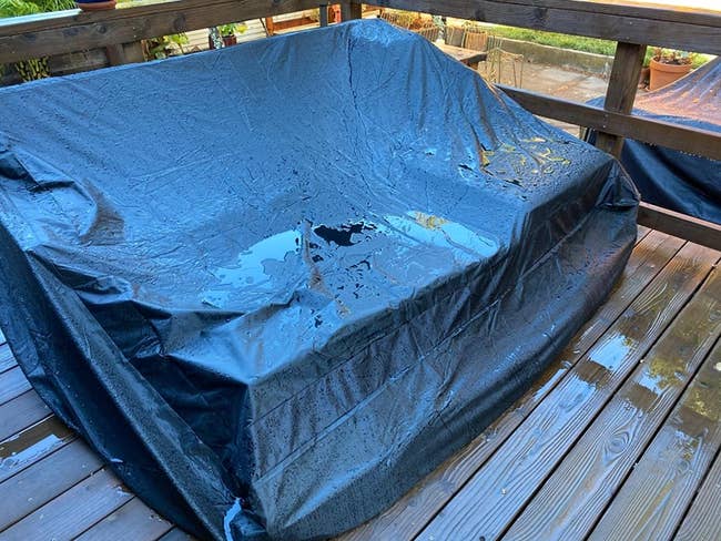 reviewer's outdoor furniture covered by furniture cover with water sitting on cover