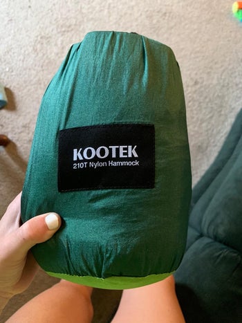 a reviewer holding the portable hammock bag