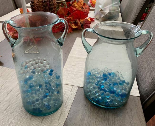 Reviewer image of two glass vases with elephant ear handles and blue marbles inside