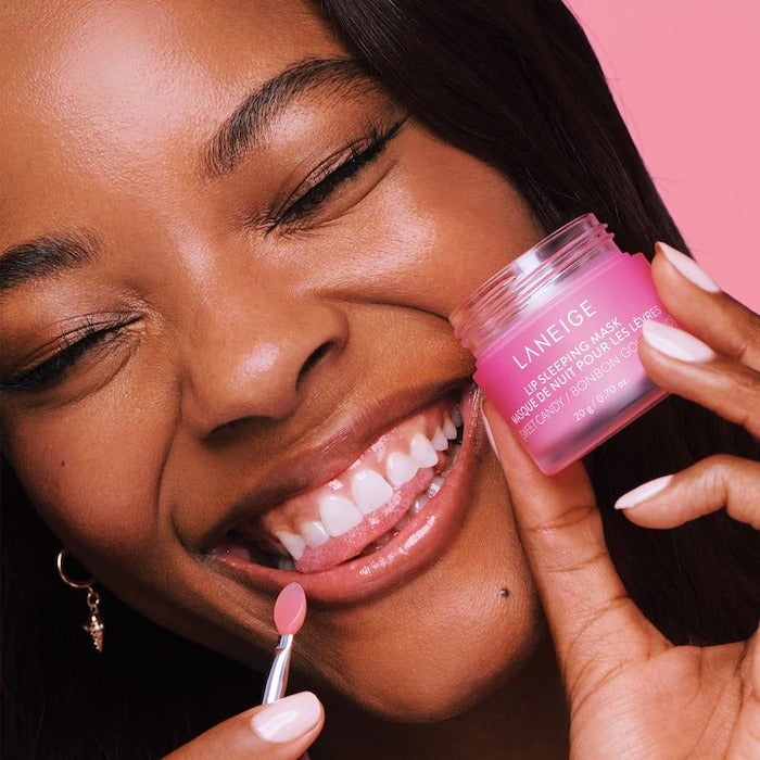 a model applying the pink jar of the original berry scent with the a small applicator