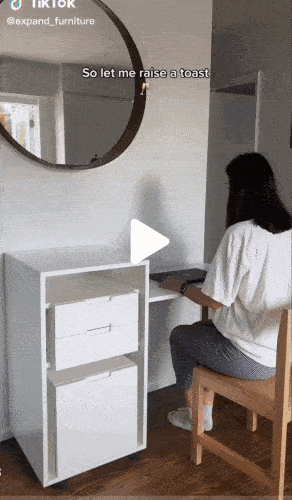 gif of a model showing how the desk folds up and the chair fits in the cabinet