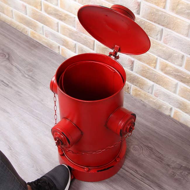 step to open iron garbage can shaped like a fire hydrant