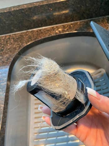 reviewer holding up a hair-filled filter