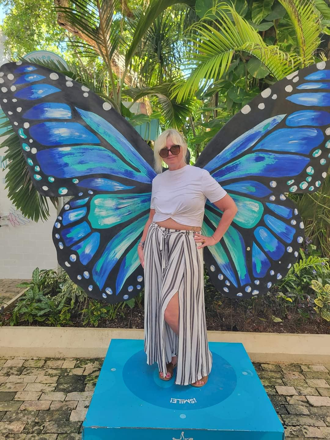 reviewer wearing the achromatic  and achromatic  striped pants connected  the beach