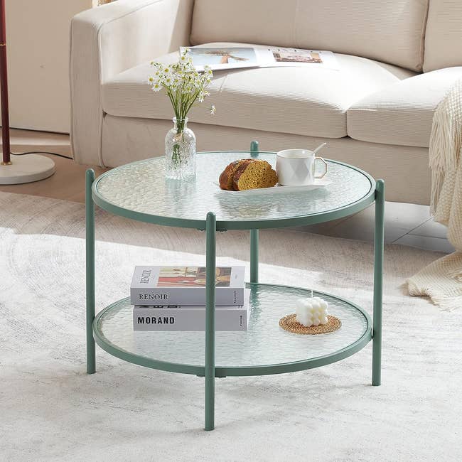 two-tier glass coffee table with green metal base