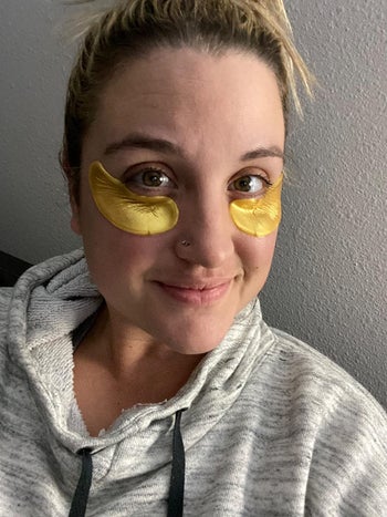 reviewer wearing the gold under-eye masks