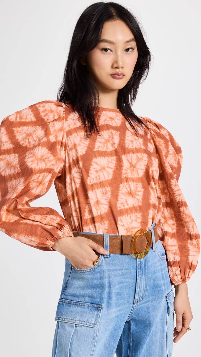 model wearing orange tie dye long sleeve top tucked into jeans