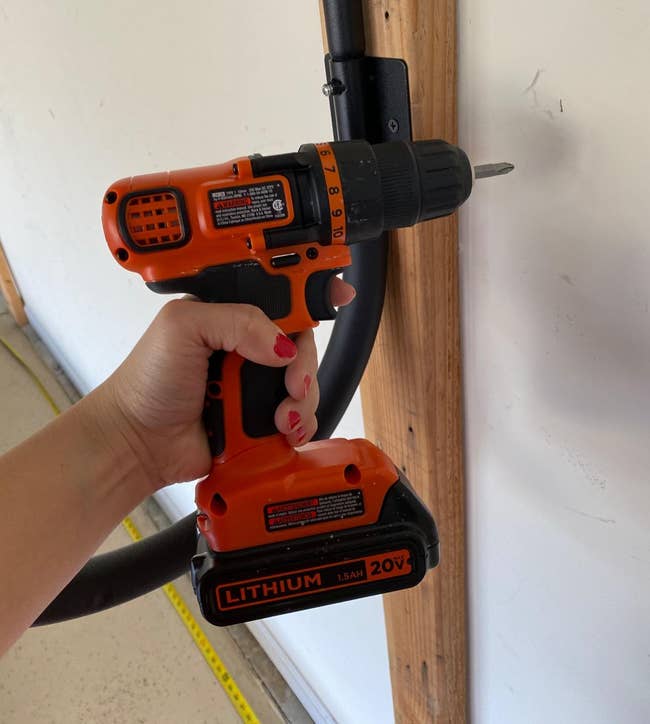 reviewer's hand holding the drill