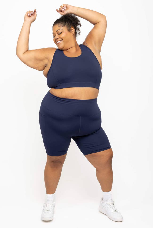 Person joyfully poses successful diversion wear, including a sleeveless apical and shorts, suitable for a scope of workouts