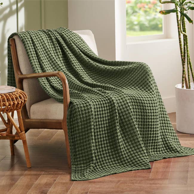 dark green waffle weave blanket draped over a chair