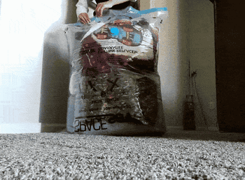 A gif of a reviewer putting blankets into the bag and sucking the air out