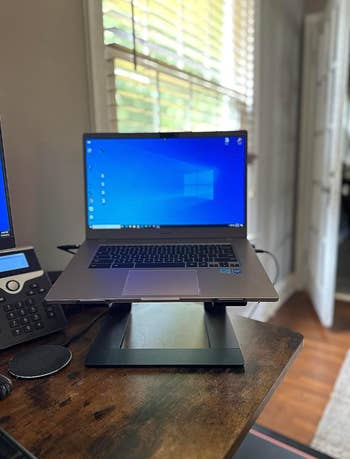 Front view of a different laptop propped on the riser 