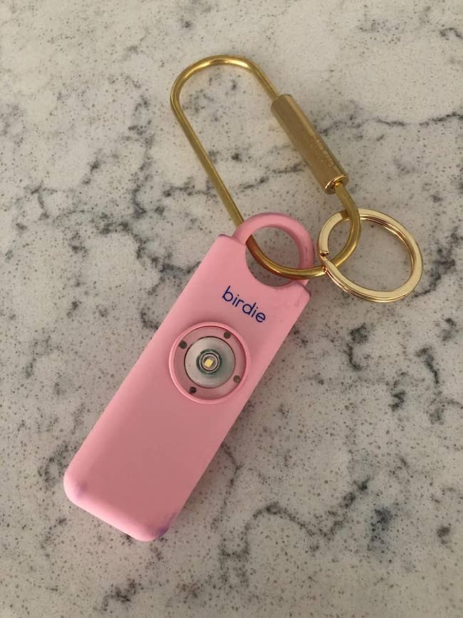 reviewer's pink alarm on a gold key loop