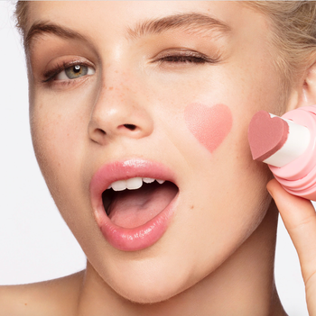 a model with a pink heart stamped onto their cheek