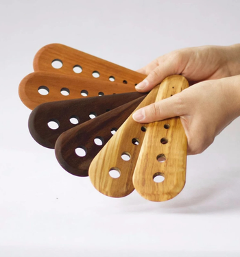 hands holding the herb strippers in the three wood types