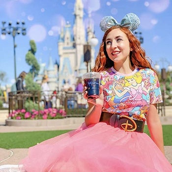 a model wearing the disney belt with a patterned shirt and pink tulle skirt
