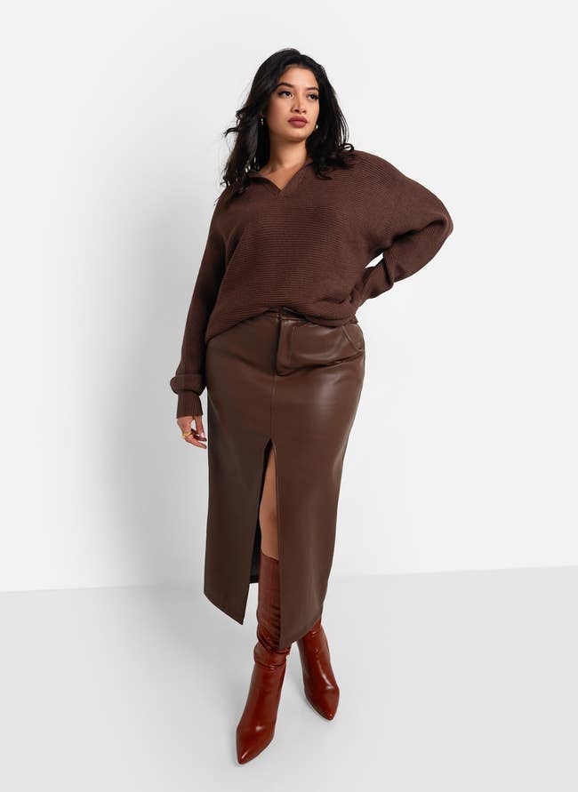 model posing in chocolate brown midi vegan leather skirt with a slit in the front