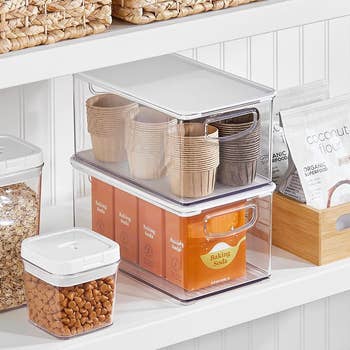 two of the bins stacked on top of each other in a pantry holding various items