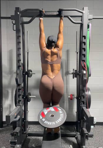 A reviewer working out while wearing the jumpsuit