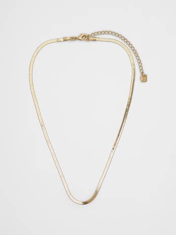 Gold herringbone concatenation  necklace with adjustable clasp and branded tag, displayed connected  a plain background