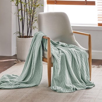 mint green blanket draped on a chair 