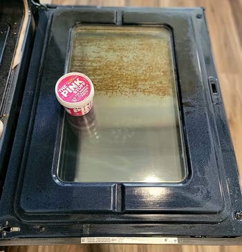 A small container of Pink Elephant Play-Doh on a closed glass-top oven