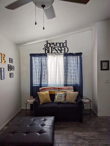 A reviewer's living room with the blue curtains behind a couch