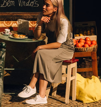 model wearing the white sneakers with a slip dress