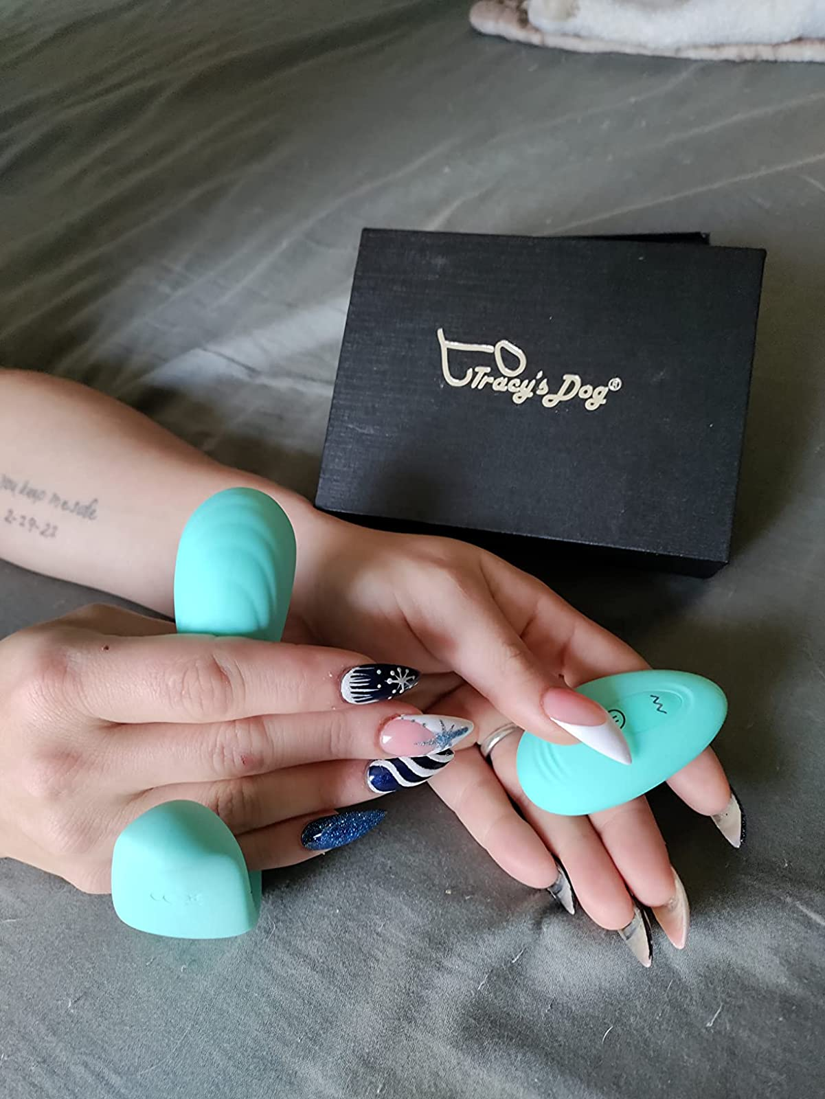Reviewer holding teal g-spot panty vibrator and wireless remote