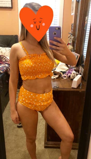 reviewer wearing suit in orange in a mirror selfie
