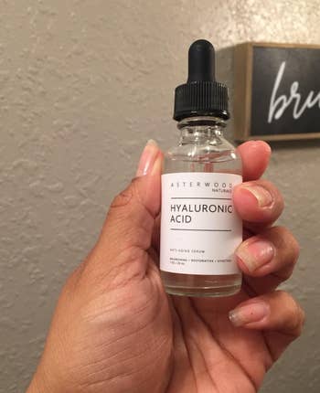 Hand holding a bottle of Asterwood Naturals Hyaluronic Acid serum