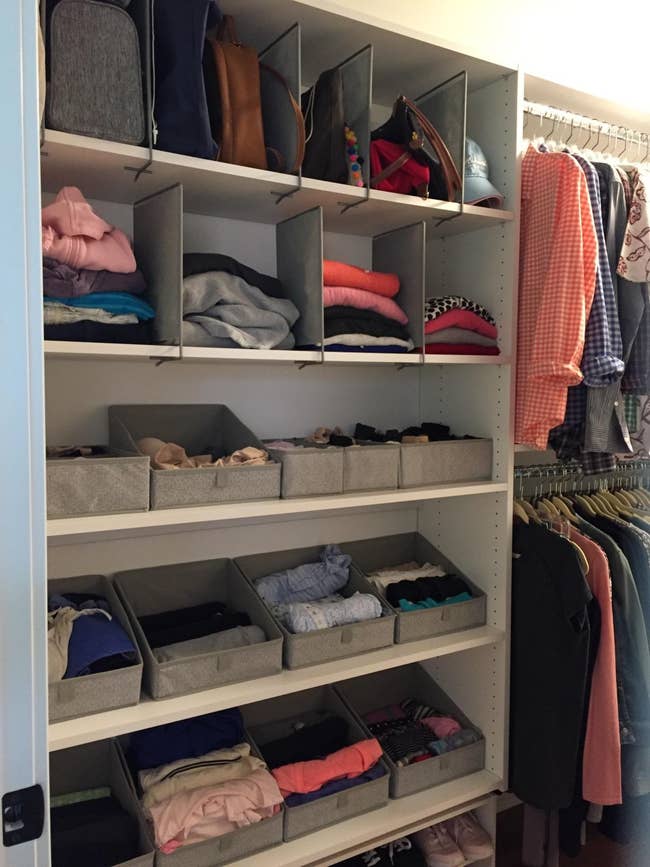 Organized closet with folded clothes, retention  bins, and hanging garments