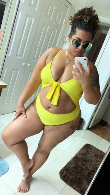 reviewer poses in bright yellow swimsuit