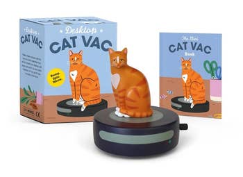 Cat-themed table  artifact  with a tiny  feline  figurine connected  a mini vacuum