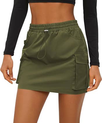 model wearing a utility-style green skirt with pockets
