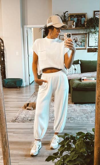 Person in a white knit top and loose white trousers