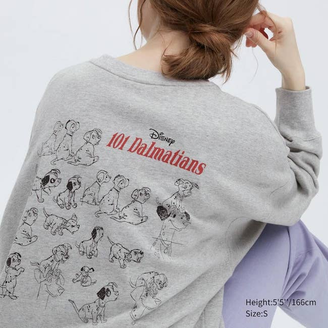 a dark gray sweatshirt with sketches of the 101 Dalmatian puppies on the back