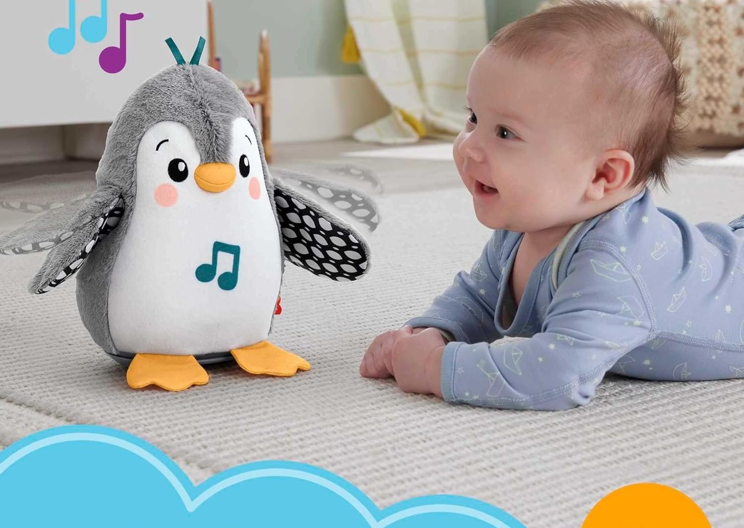 Baby on tummy facing a musical penguin toy in a nursery setting.