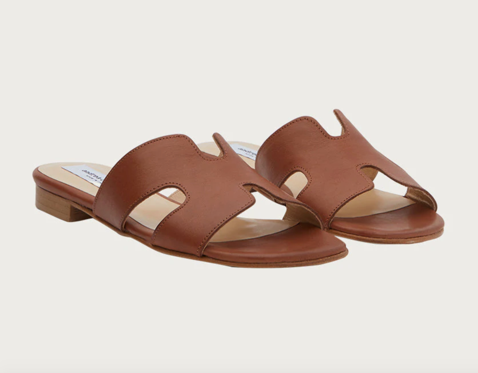 The sandals in a dark tan color with a small heel