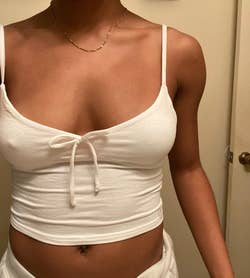 reviewer wearing a white crop top with front tie detail and matching bottoms in a casual setting