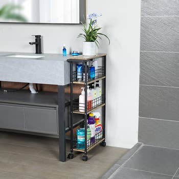 black slim cart stored next to a bathroom sink holding various toiletries