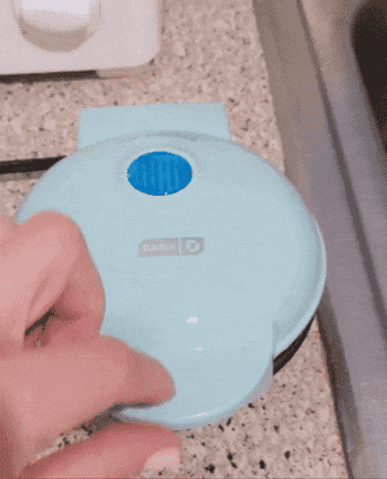 gif of another reviewer opening the mini aqua appliance to reveal cooked waffle