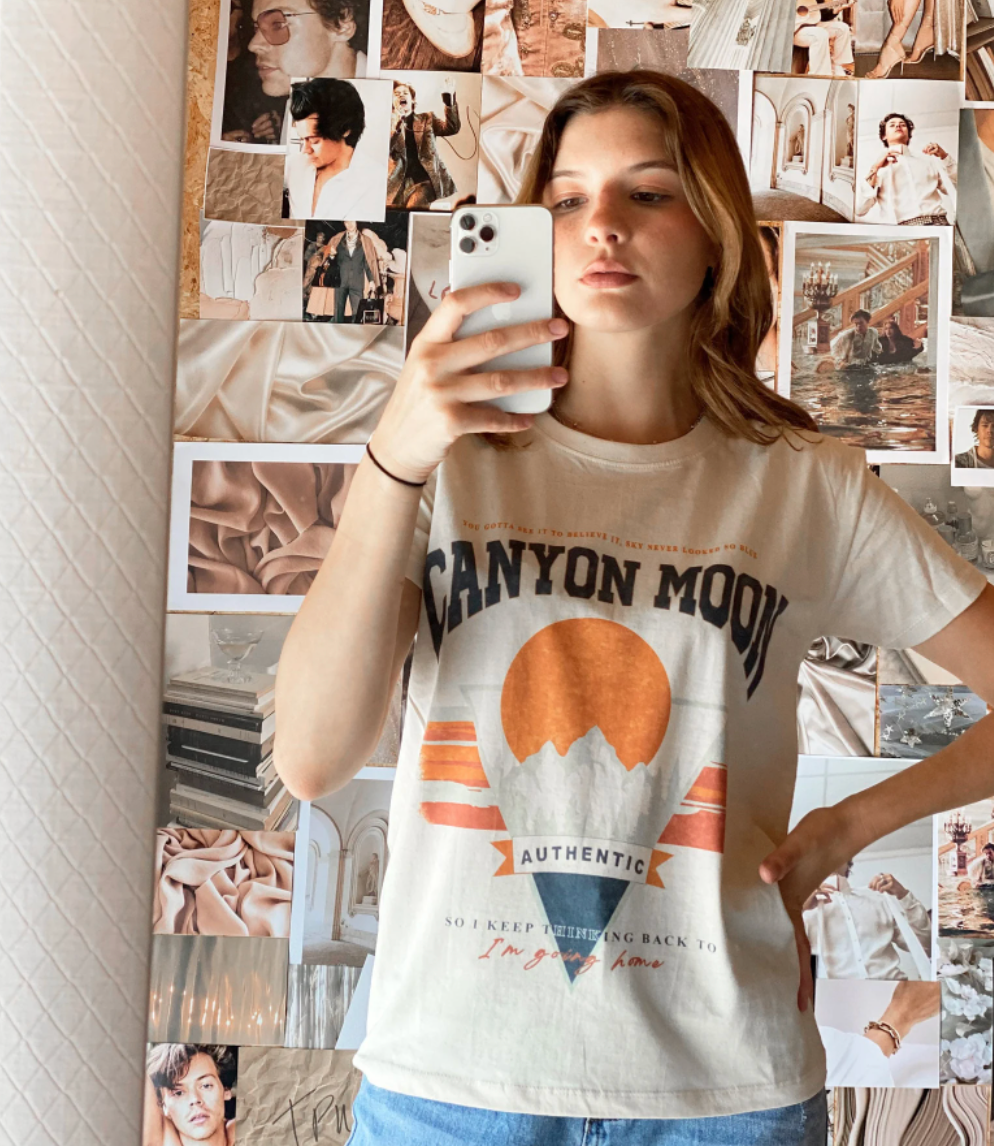 person taking a mirror selfie while wearing the canyon moon tee