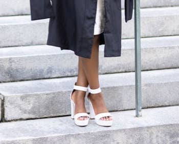 Reviewer in graduation outfit wearing white heels