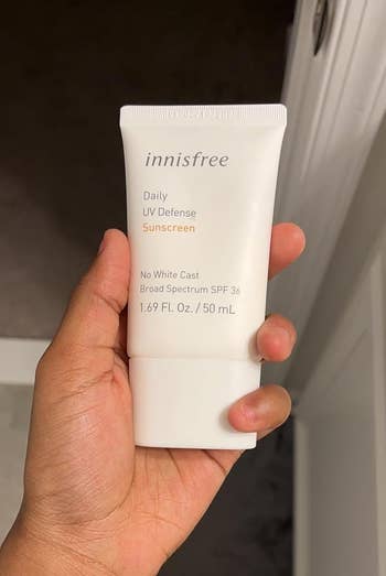 Hand holding a conduit of Innisfree Daily UV Defense Sunscreen SPF 36, labeled