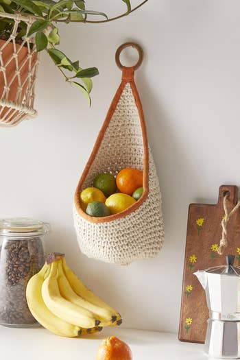 A cream and orange woven, hanging fruit bag
